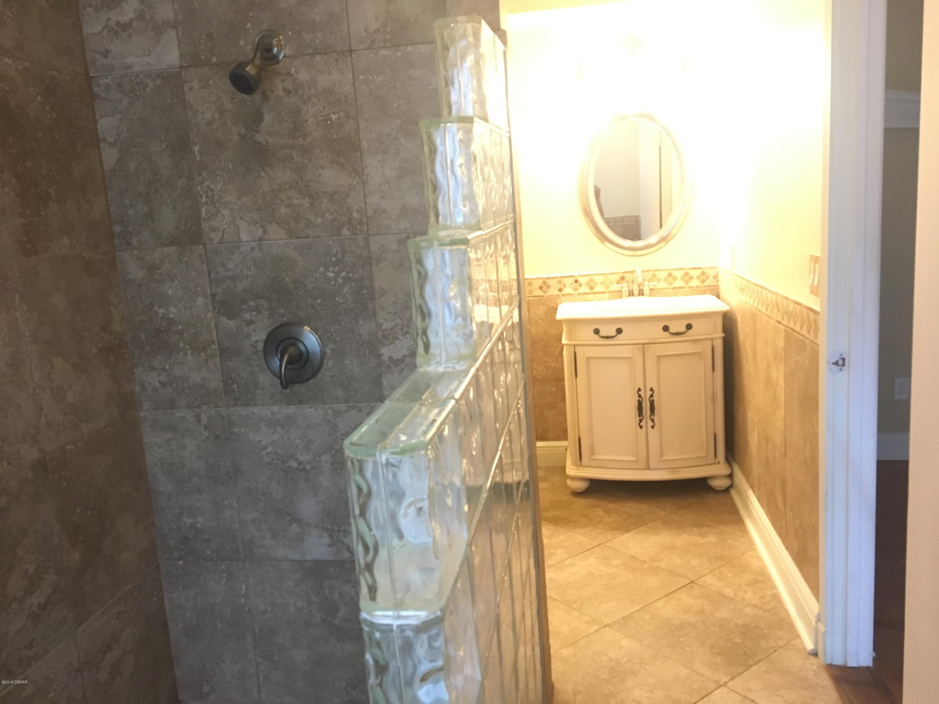 132 Tern Court Daytona Beach, FL 32119 - Photo 25 of 34 a bathroom with a sink a mirror and shower