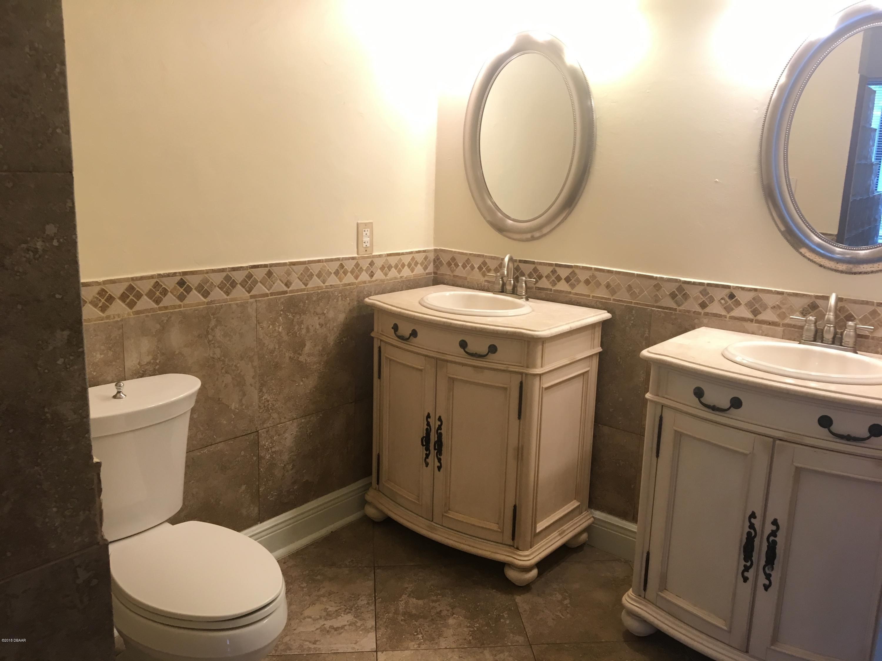 132 Tern Court Daytona Beach, FL 32119 - Photo 26 of 34 a bathroom with a granite countertop toilet sink and mirror