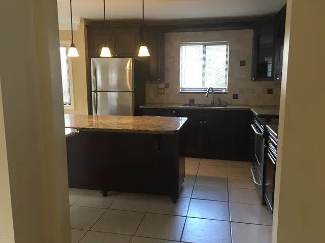 a kitchen with stainless steel appliances granite countertop a refrigerator and a stove