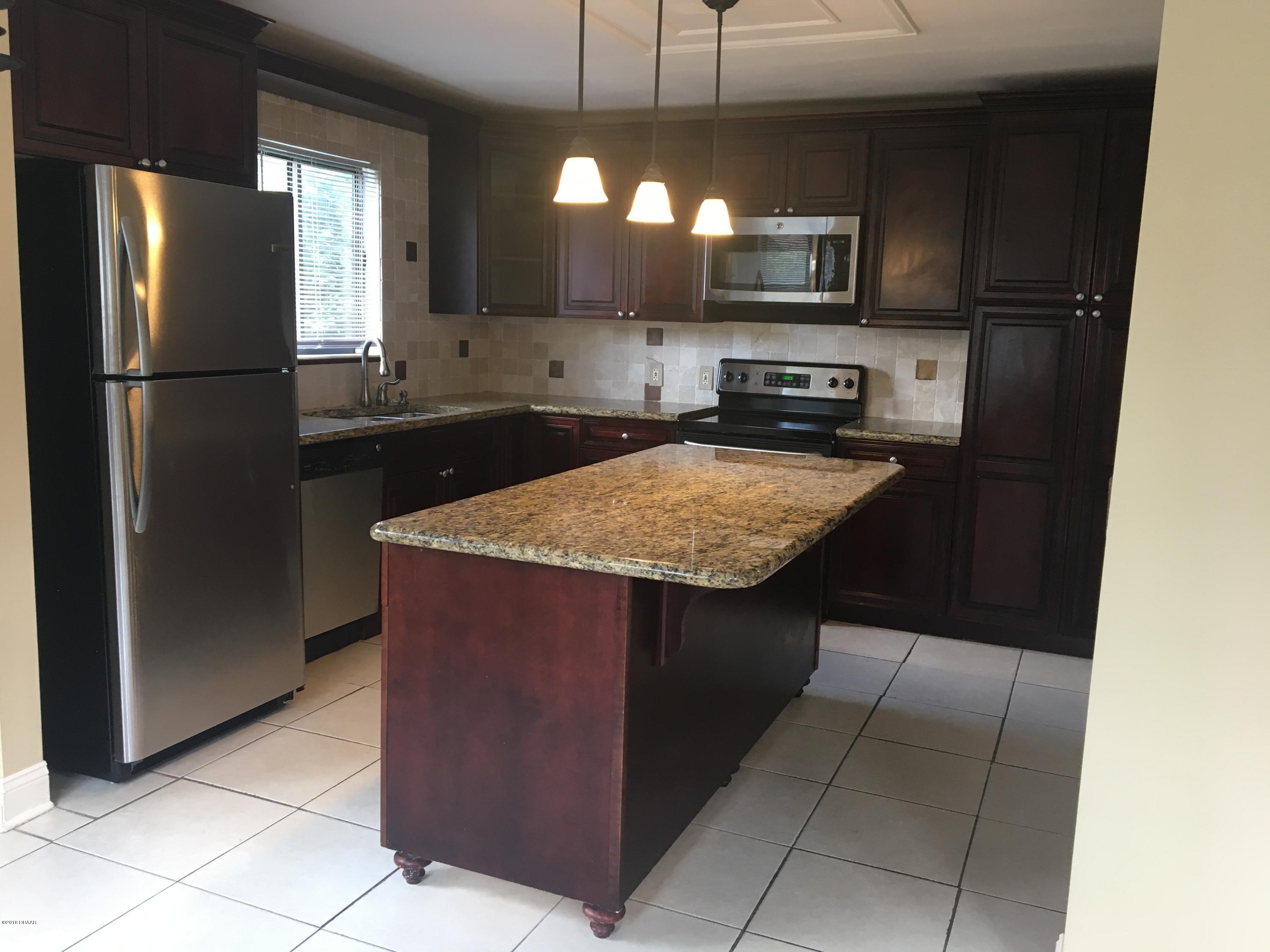 132 Tern Court Daytona Beach, FL 32119 - Photo 10 of 34 a kitchen with stainless steel appliances granite countertop a refrigerator and a stove
