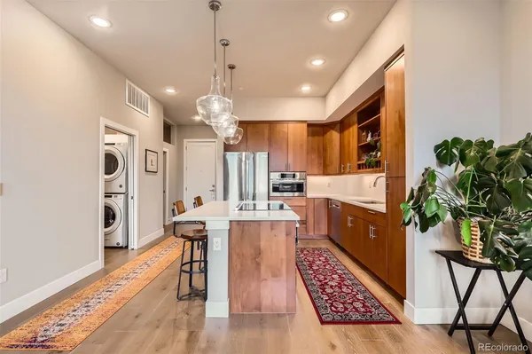 a kitchen that has a lot of cabinets a sink and stainless steel appliances