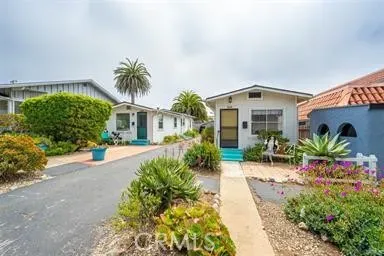 a front view of a house with a yard and potted plants