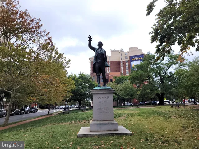 a front view of a house with a garden and trees