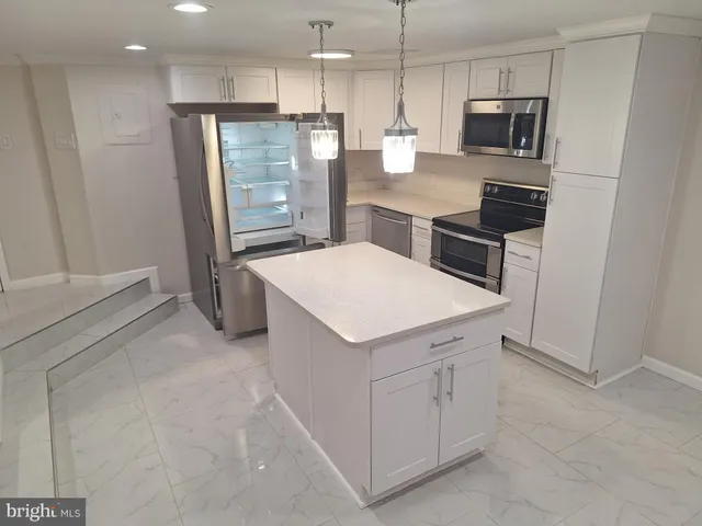 a kitchen with stainless steel appliances a refrigerator sink and microwave