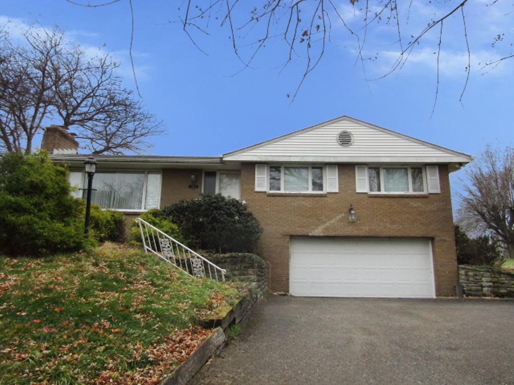 a front view of a house with yard and green space