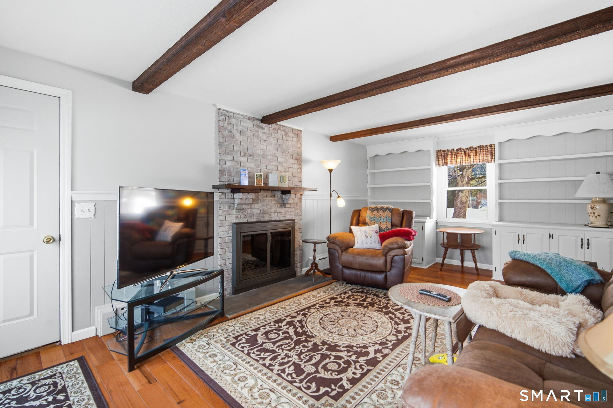 a living room with furniture a flat screen tv and a fireplace