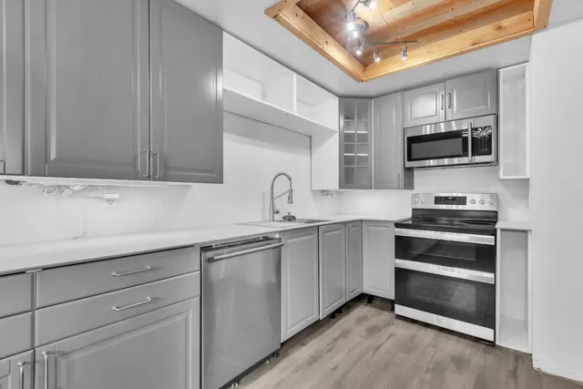 a kitchen with stainless steel appliances a stove sink microwave and cabinets