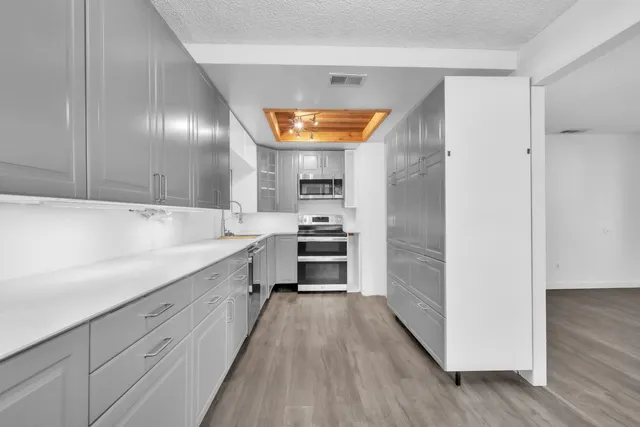 a kitchen with granite countertop a oven and a refrigerator