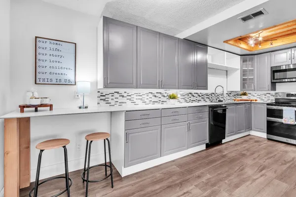 a kitchen with kitchen island granite countertop wooden floors and white stainless steel appliances