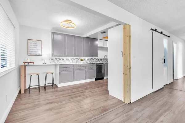 a view of kitchen with wooden floor and electronic appliances