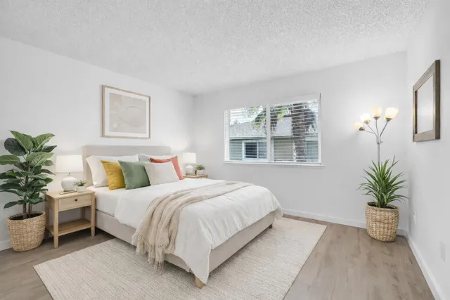 a bedroom with a large bed and potted plant