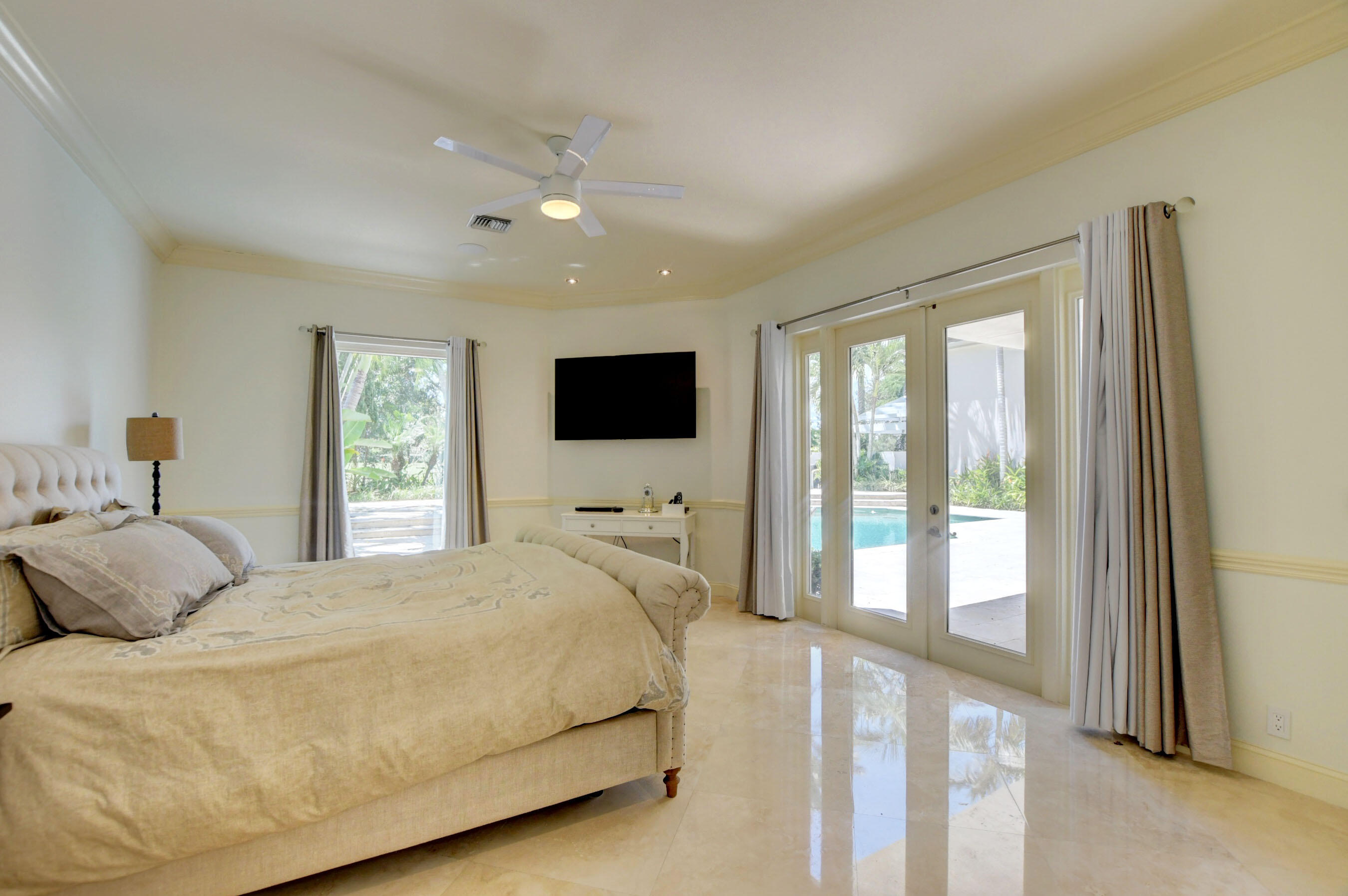 6174 Northwest 24th Way Boca Raton, FL 33496 - Photo 27 of 58 a bedroom with a large bed and a flat tv screen