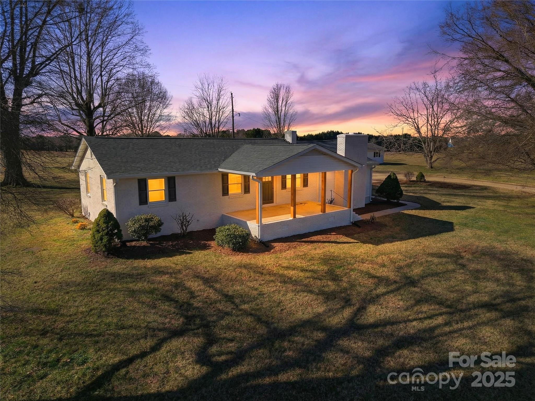 a view of a house with backyard and trees