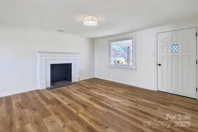 a view of empty room with window and fireplace