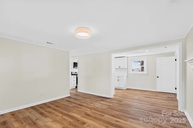 a view of empty room with wooden floor