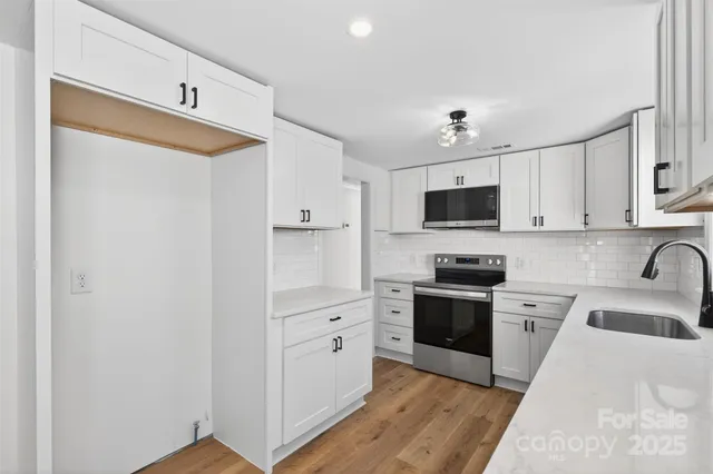 a kitchen with stainless steel appliances a stove sink and cabinets