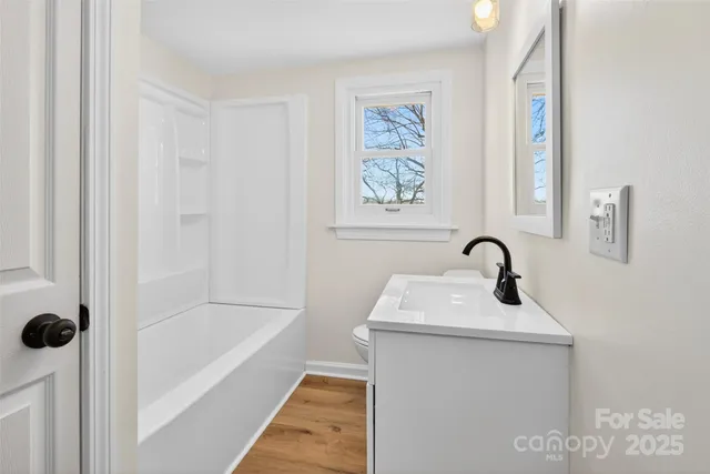 a bathroom with a sink mirror and bathtub