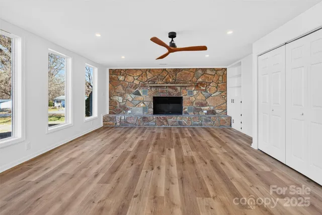 wooden floor fireplace and windows in an empty room