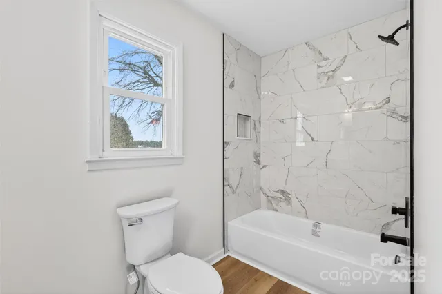 a bathroom with a toilet and a bath tub