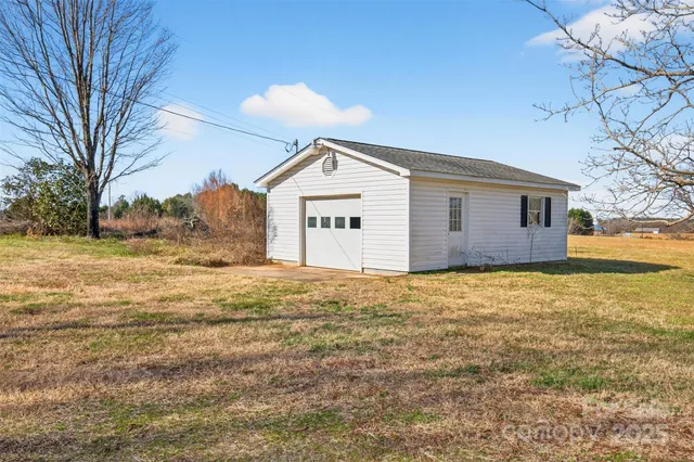 a view of an house with backyard and trees