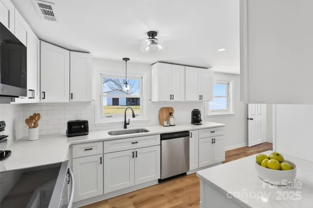 a kitchen with a sink cabinets and wooden floor