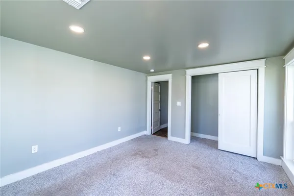 an empty room with closet and bathroom