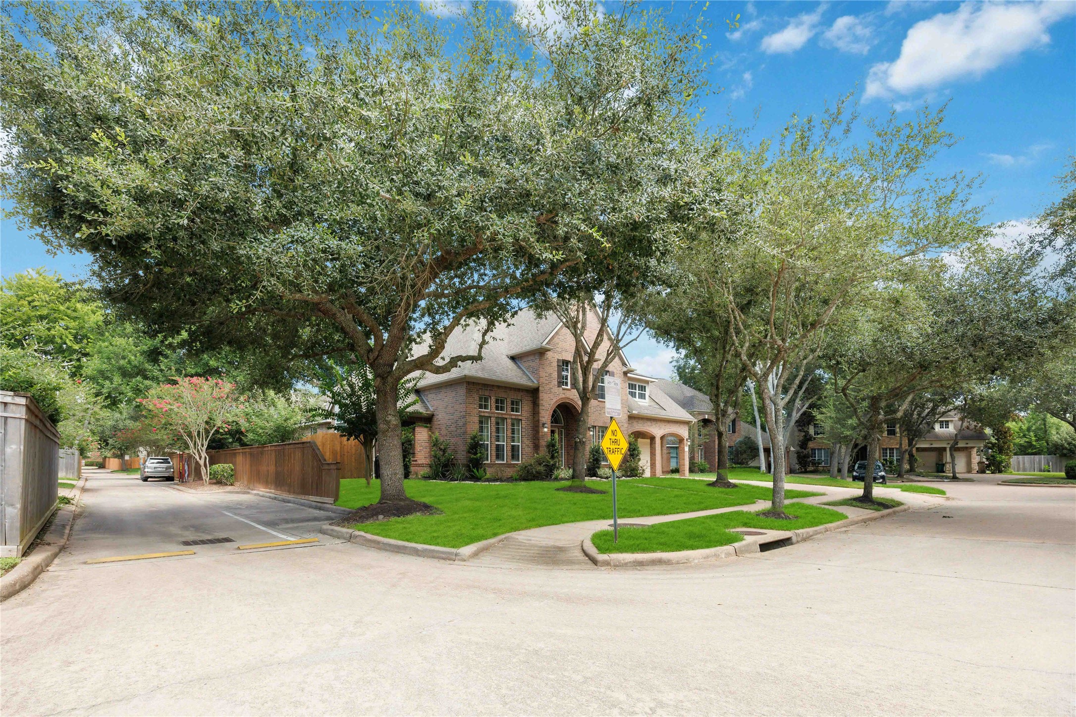 3303 Raleigh Row Missouri City, TX 77459 - Photo 4 of 50 Charming brick home nestled on a corner lot, surrounded by mature trees and lush greenery, offering a serene neighborhood setting. Extra parking in Alley way!