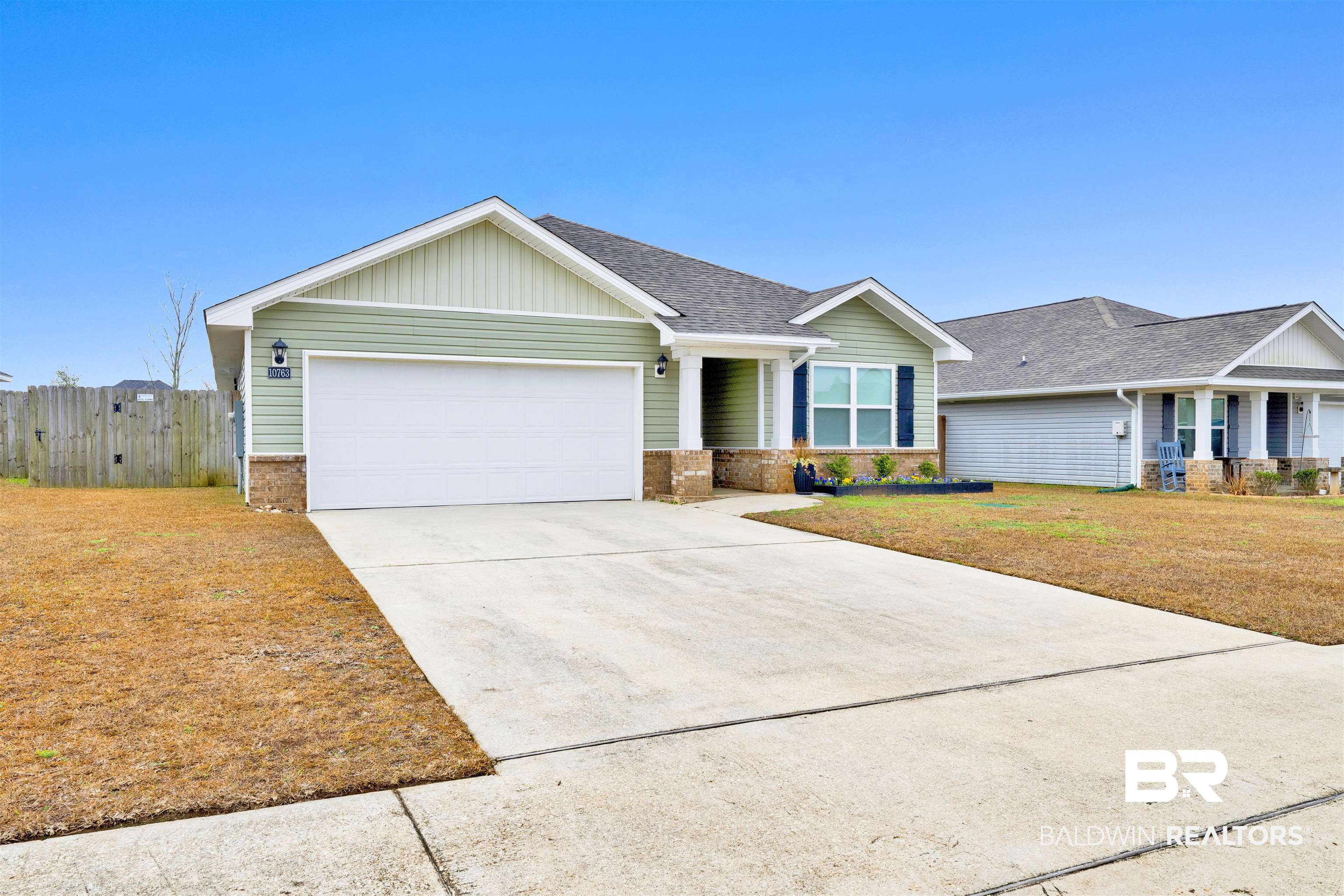 10763 Paget Drive North Mobile, AL 36608 - Photo 3 of 24 Single story home with an attached garage, driveway, a shingled roof, board and batten siding, and brick siding