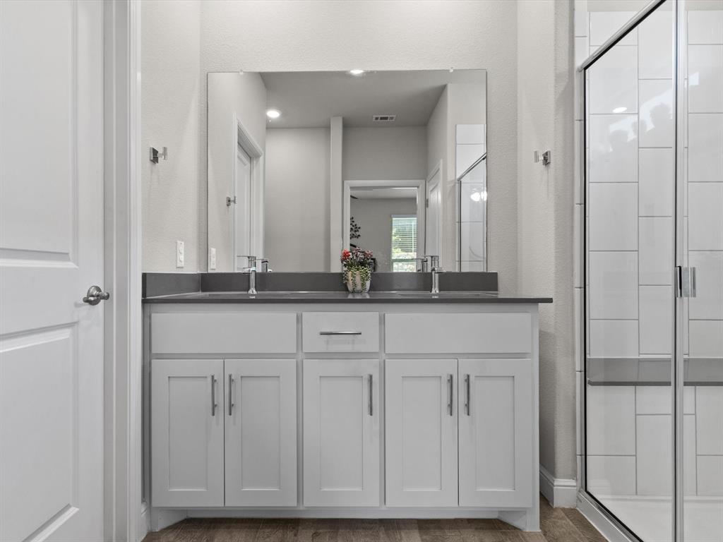 270 Lunayena Road Rhome, TX 76078 - Photo 33 of 37 The primary bathroom features a functional layout with dual vanities, ample storage, and a private shower area, offering everyday convenience and comfort in a well-designed space.
