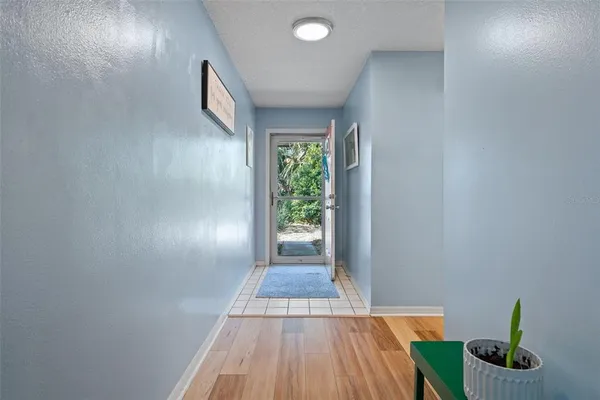 a view of a hallway with wooden floor and a window