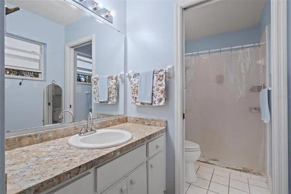 a bathroom with a granite countertop sink a toilet and a mirror