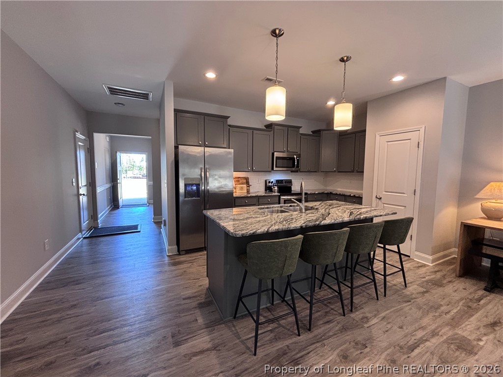 7720 Rufus Johnson Road Fayetteville, NC 28306 - Photo 26 of 50 a open kitchen with stainless steel appliances granite countertop a stove a refrigerator a kitchen island a sink and a refrigerator