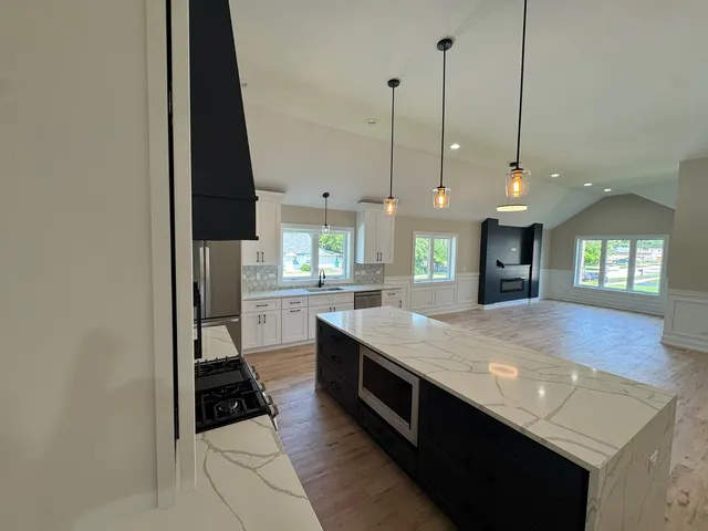 a kitchen with kitchen island a stove a counter top space and a sink