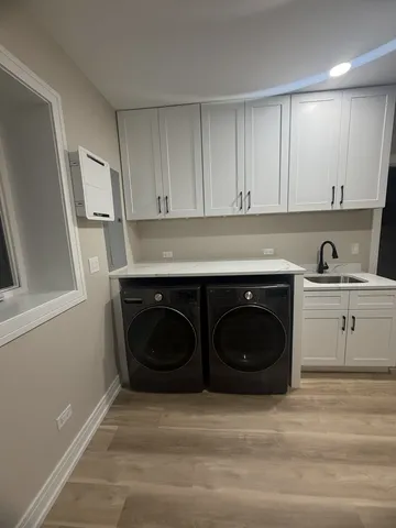 a utility room with sink dryer and washer