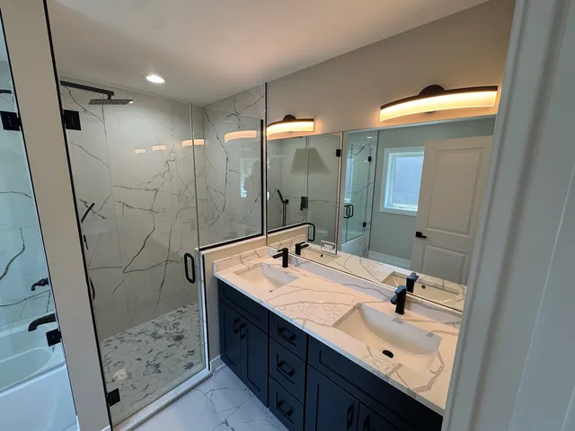 a bathroom with a sink mirror and shower