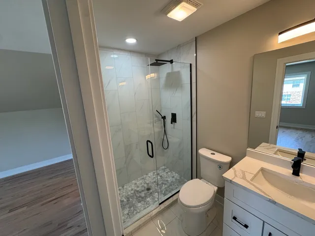 a bathroom with a granite countertop toilet sink and shower