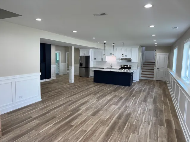 a kitchen with stainless steel appliances kitchen island granite countertop a refrigerator and a stove top oven