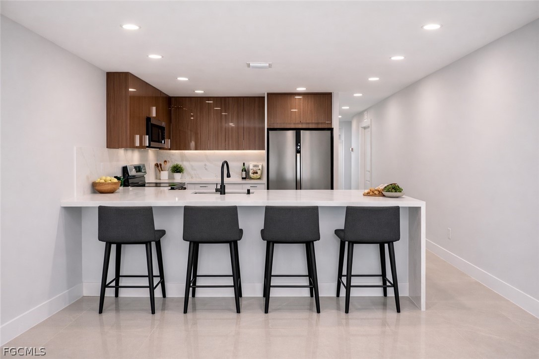 4529 18th Street Southwest Lehigh Acres, FL 33973 - Photo 30 of 50 a kitchen with a dining table chairs and refrigerator