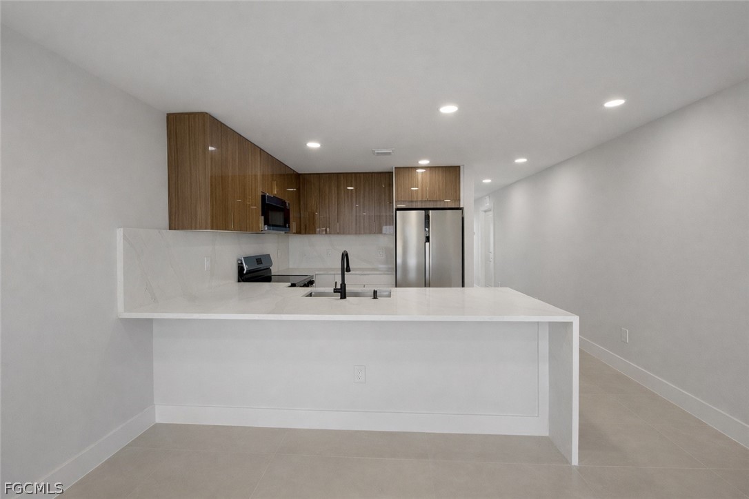 4529 18th Street Southwest Lehigh Acres, FL 33973 - Photo 31 of 50 a large white kitchen with sink and white cabinets