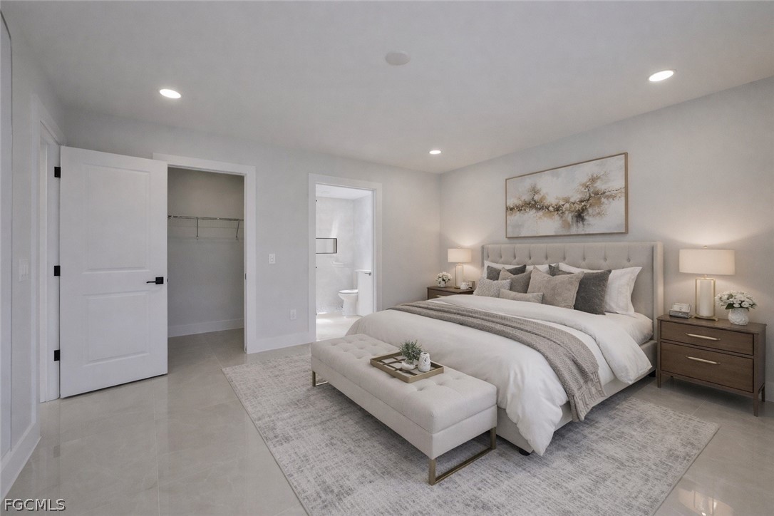 4529 18th Street Southwest Lehigh Acres, FL 33973 - Photo 36 of 50 a spacious bedroom with a bed and a painting