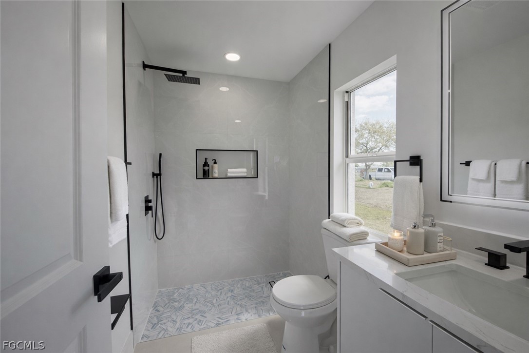 4529 18th Street Southwest Lehigh Acres, FL 33973 - Photo 38 of 50 a bathroom with a sink toilet and shower