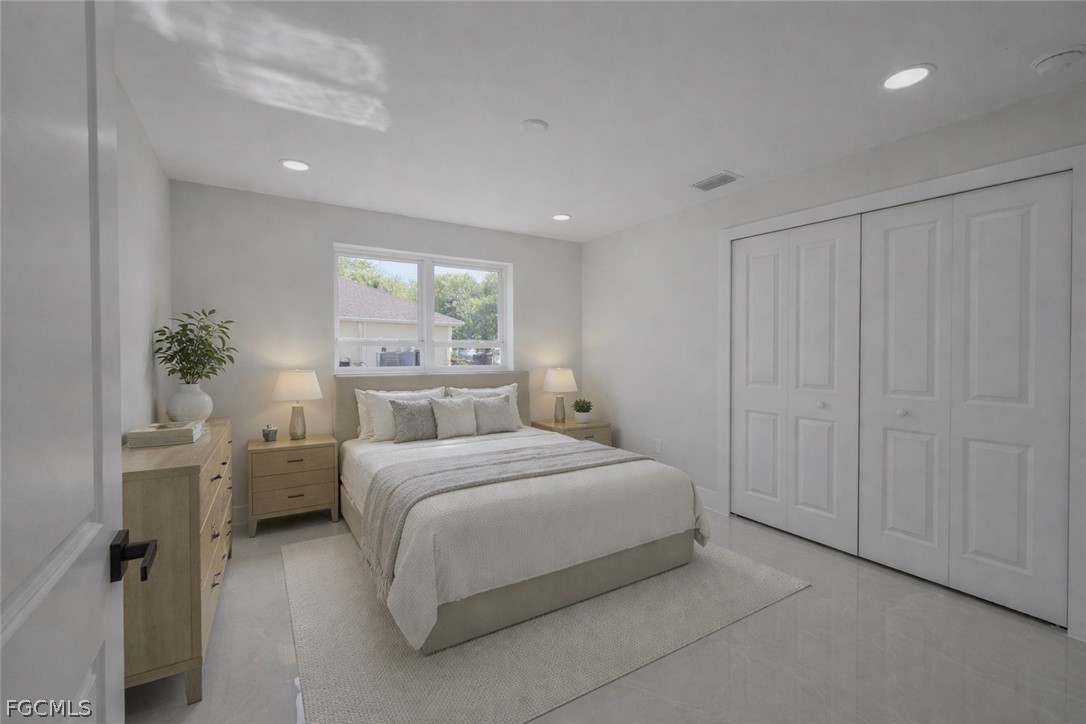 4529 18th Street Southwest Lehigh Acres, FL 33973 - Photo 39 of 50 a bedroom with a large bed and a potted plant