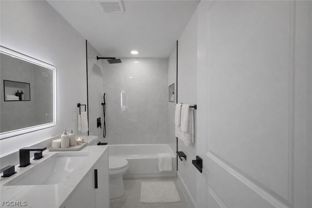 4529 18th Street Southwest Lehigh Acres, FL 33973 - Photo 41 of 50 a bathroom with a tub sink toilet and a mirror