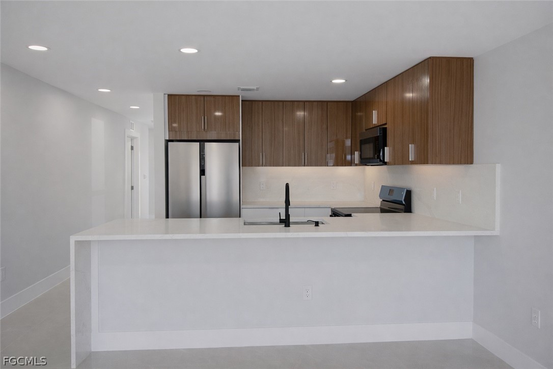 4529 18th Street Southwest Lehigh Acres, FL 33973 - Photo 6 of 50 a large white kitchen with a sink and large mirror