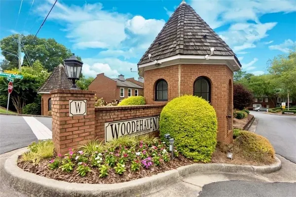 a view of a brick house with a yard plants and a fountain