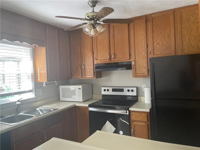 a kitchen with a refrigerator a sink and cabinets