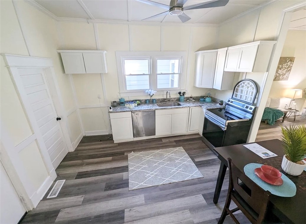 208 Hampton Street Iva, SC 29655 - Photo 6 of 19 This bright kitchen features modern appliances and durable flooring, perfect for everyday living.