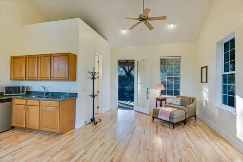 a kitchen with stainless steel appliances granite countertop a stove top oven a sink dishwasher and a dining table with wooden floor