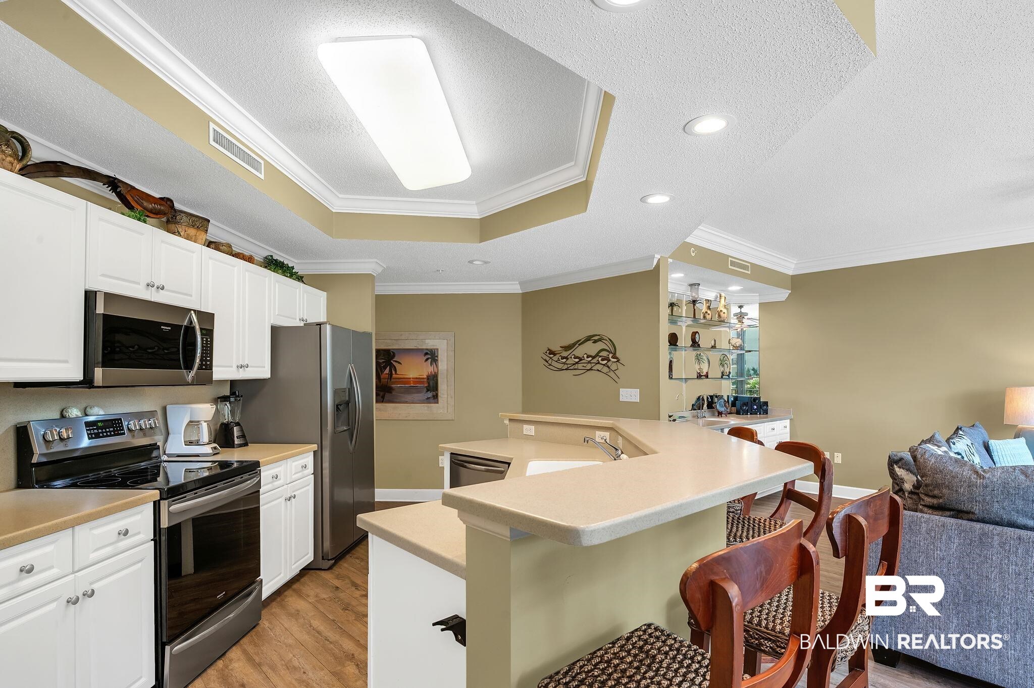 27580 Canal Road, Unit 1214 AND BOAT SLIP #62 Orange Beach, AL 36561 - Photo 67 of 67 Kitchen featuring light wood-type flooring, open floor plan, visible vents, a kitchen bar, and stainless steel appliances