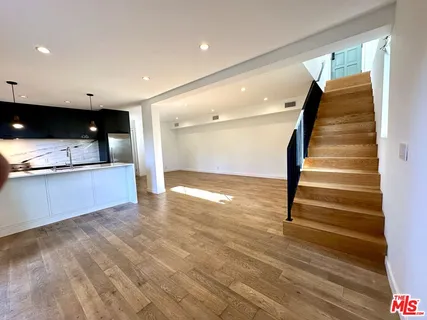 a view of kitchen and hall with wooden floor
